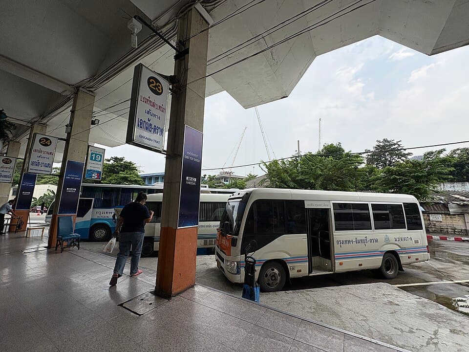 Bus boarding area at Ekkamai Bus Terminal with platform signs and minibuses.